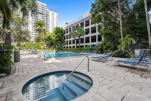 view of swimming pool with a patio and a hot tub