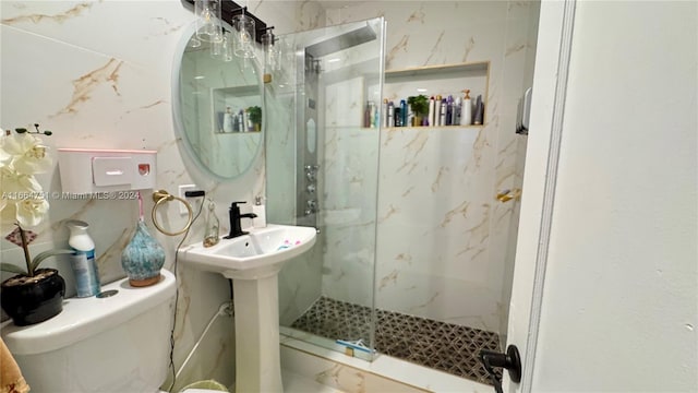 bathroom featuring a shower with shower door and toilet