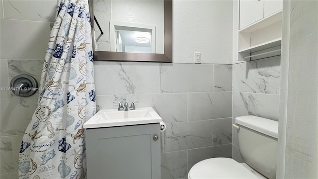 bathroom with toilet, vanity, tile walls, and curtained shower