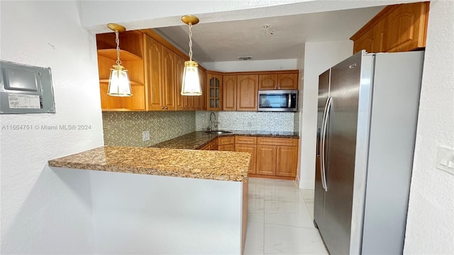 kitchen with backsplash, appliances with stainless steel finishes, hanging light fixtures, sink, and kitchen peninsula