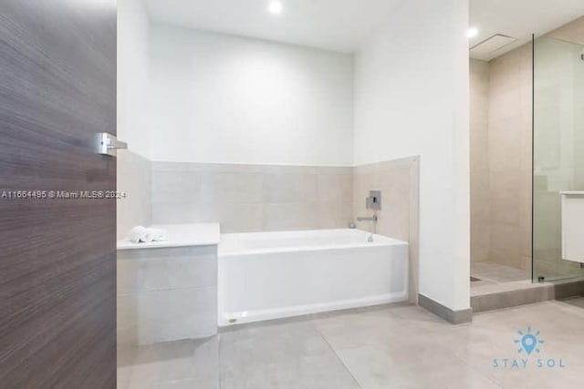 bathroom featuring tile walls, shower with separate bathtub, tile patterned floors, and vanity