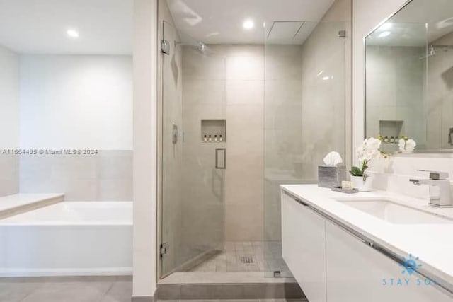 bathroom featuring vanity and separate shower and tub