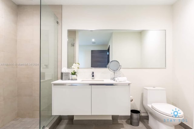 bathroom with tile patterned flooring, walk in shower, vanity, and toilet