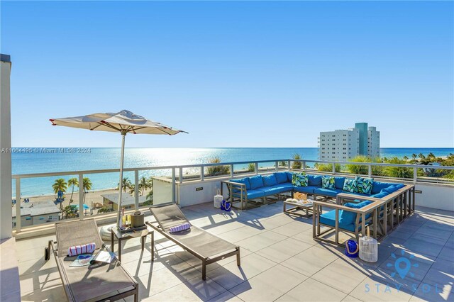 view of patio with a water view, an outdoor living space, and a balcony