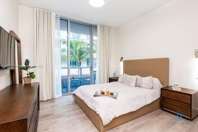 bedroom with access to outside and light hardwood / wood-style flooring