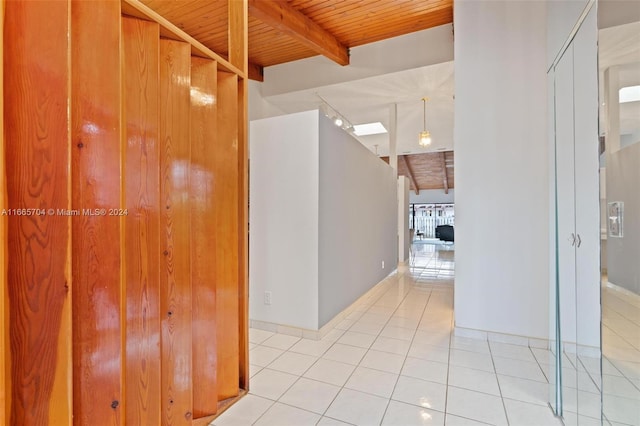 hall featuring light tile patterned flooring, wood ceiling, and lofted ceiling with beams