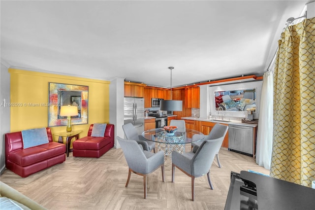 dining area featuring ornamental molding, sink, and light parquet flooring