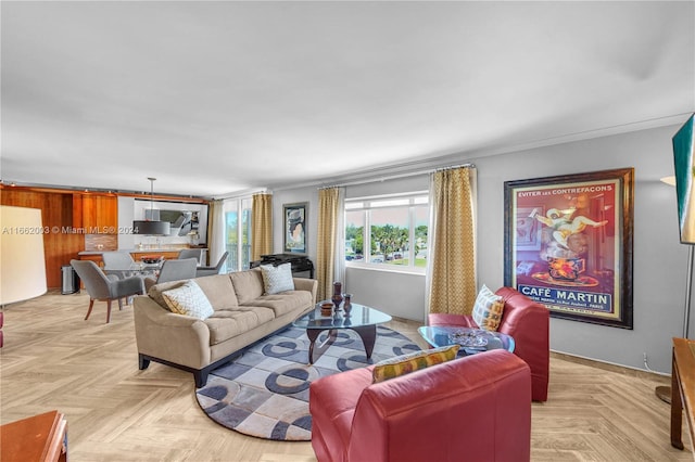 living room featuring light parquet flooring, crown molding, and wooden walls