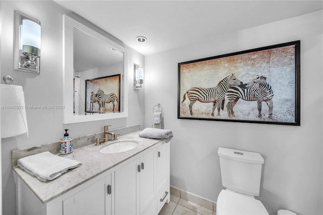 bathroom featuring vanity, tile patterned flooring, and toilet