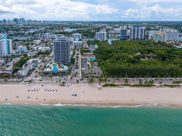 birds eye view of property featuring a water view and a beach view