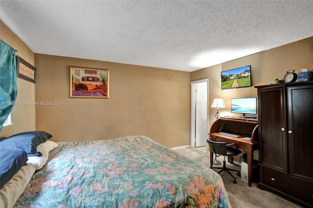 bedroom featuring a textured ceiling and light colored carpet