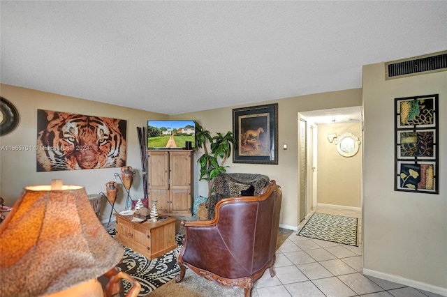 tiled living room featuring a textured ceiling