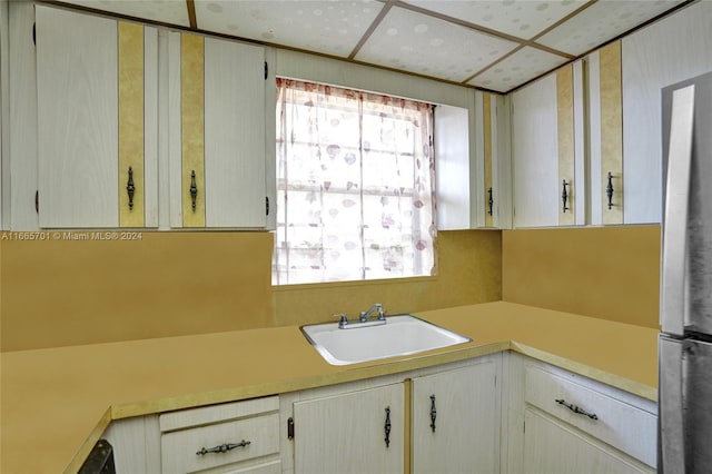 kitchen featuring a healthy amount of sunlight, sink, and a paneled ceiling