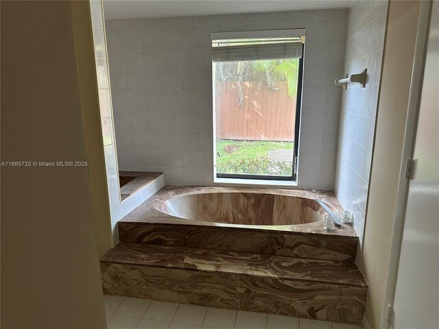 bathroom with tile patterned flooring and a washtub