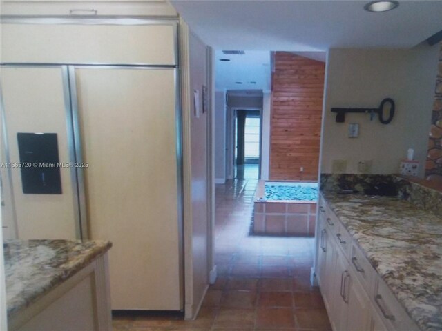 kitchen with light stone countertops and white cabinets