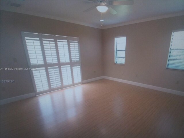 spare room featuring hardwood / wood-style floors, a wealth of natural light, and ornamental molding