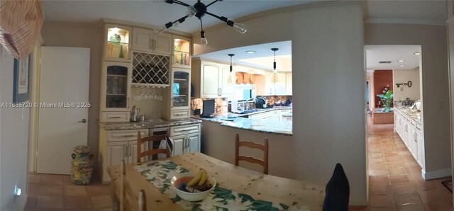 kitchen featuring light tile patterned flooring, decorative light fixtures, and light stone countertops