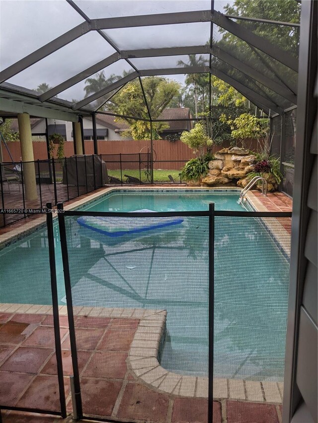 view of swimming pool with a lanai