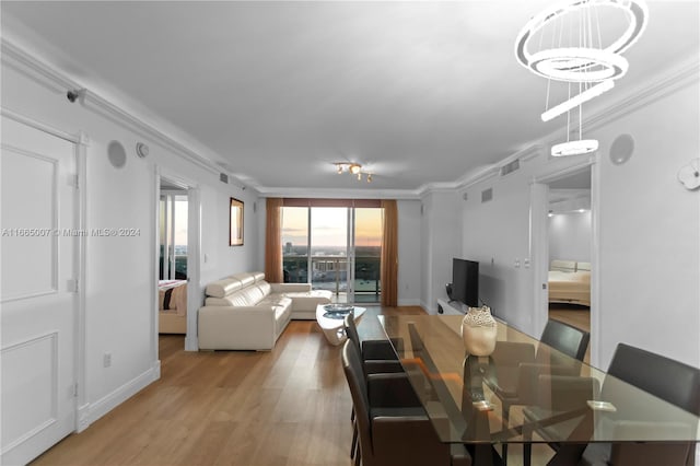 dining area featuring light wood-type flooring and ornamental molding