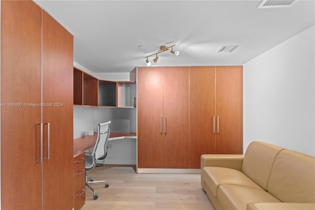 office space featuring light wood-type flooring and built in desk