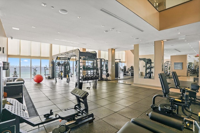 gym with floor to ceiling windows and a water view