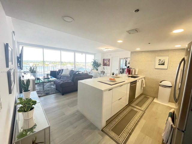 kitchen featuring light wood-type flooring, white cabinetry, sink, and stainless steel appliances