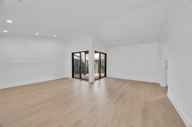 spare room featuring light wood-type flooring and lofted ceiling