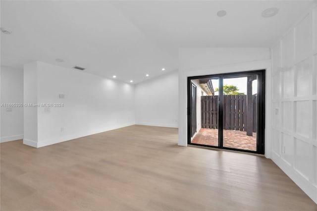 empty room featuring light hardwood / wood-style flooring and vaulted ceiling