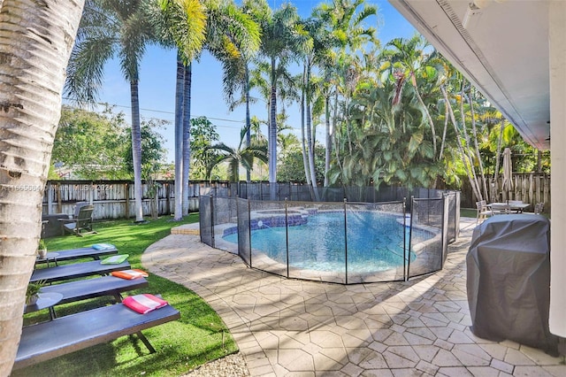 view of pool with a grill, an in ground hot tub, a patio area, and a yard