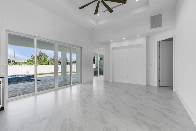 spare room with a tray ceiling, a towering ceiling, ceiling fan, and wine cooler