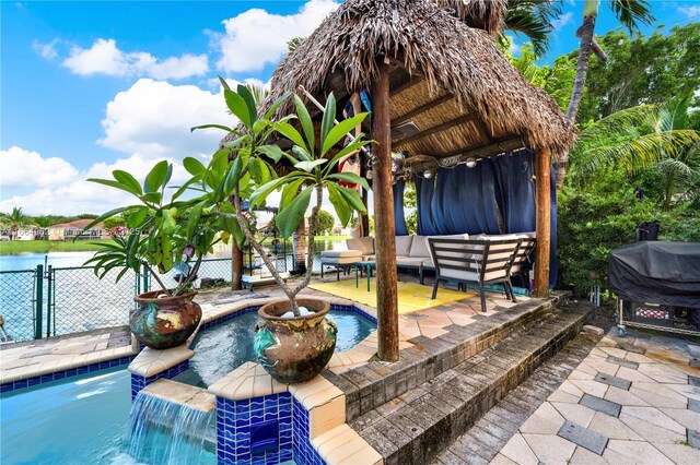 view of pool featuring a grill, pool water feature, an outdoor hangout area, a gazebo, and a water view