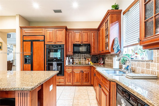 kitchen with light stone countertops, black appliances, sink, decorative backsplash, and light tile patterned floors