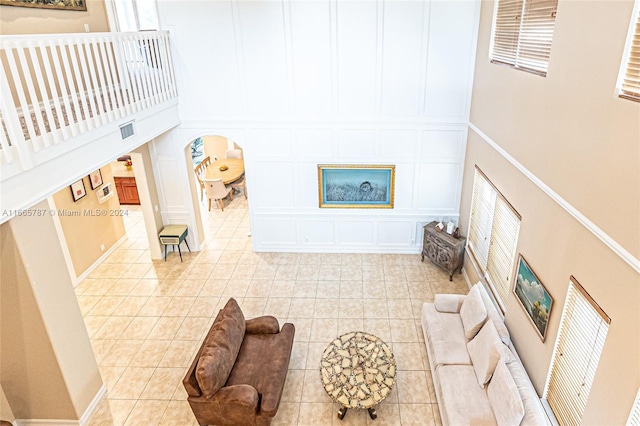 living room with light tile patterned flooring and a high ceiling