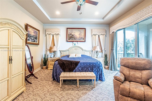 carpeted bedroom featuring a raised ceiling, access to outside, and ceiling fan