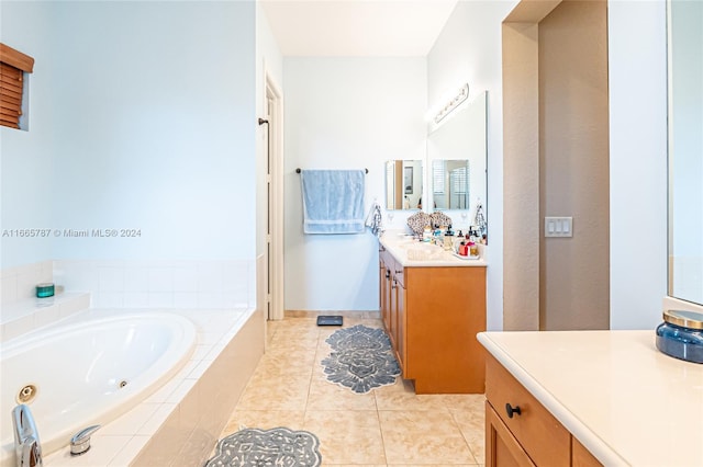 bathroom with vanity, tile patterned flooring, and tiled tub