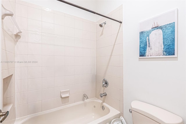 bathroom with tiled shower / bath and toilet