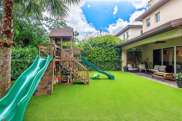 view of play area featuring a patio area, a lawn, and ceiling fan