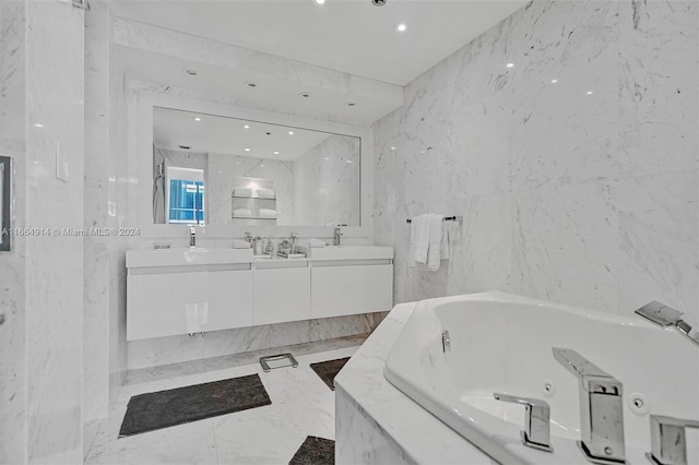 bathroom featuring tile walls, tiled tub, and vanity