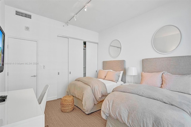 bedroom featuring rail lighting and a closet