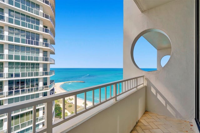 balcony featuring a view of the beach and a water view