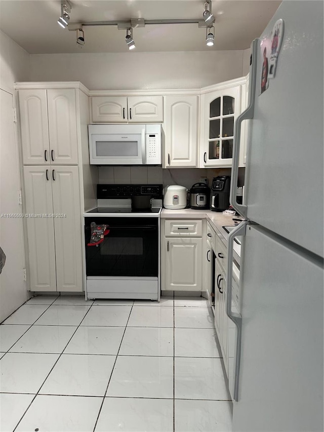 kitchen featuring white appliances, white cabinetry, and light tile patterned floors