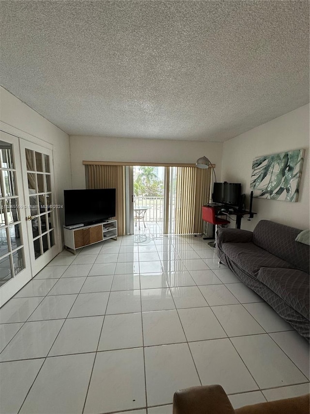 tiled living room featuring french doors and a textured ceiling