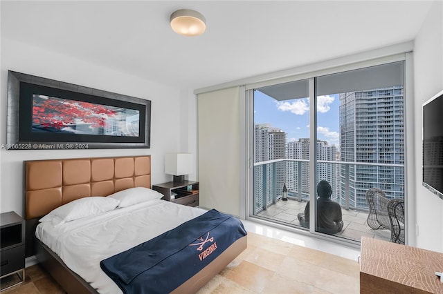 bedroom with access to outside and a wall of windows