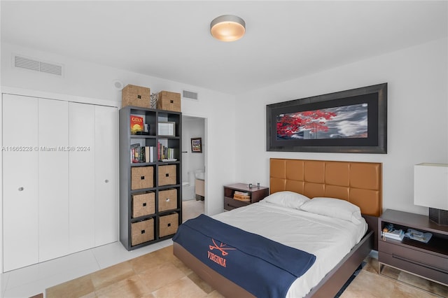 bedroom with tile patterned flooring and a closet