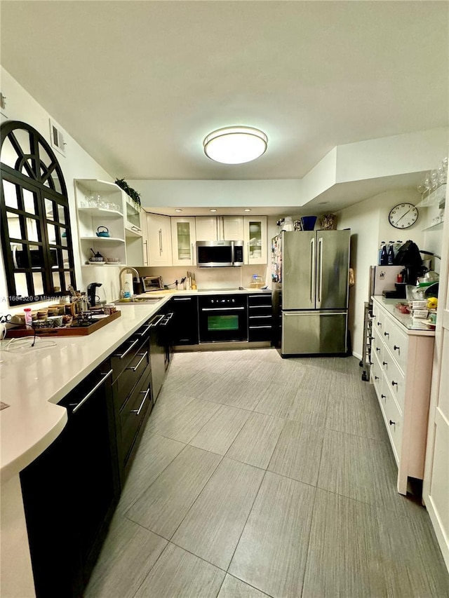 kitchen featuring white cabinetry, sink, and black appliances