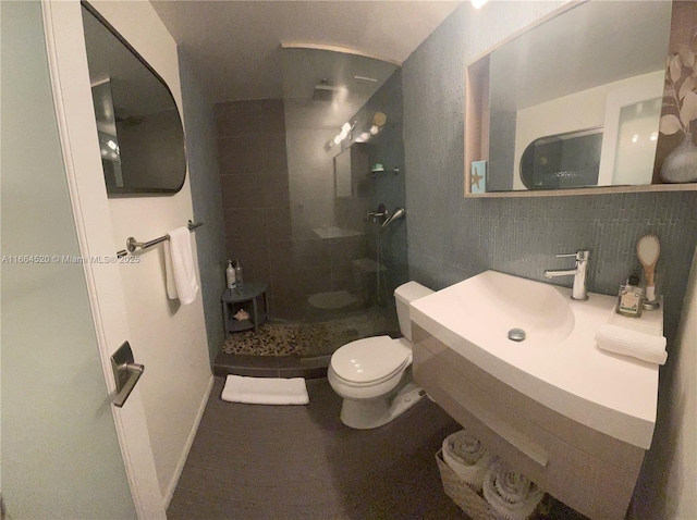 bathroom with tasteful backsplash, tile walls, toilet, and tiled shower