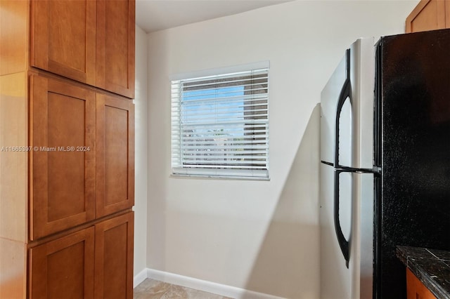 kitchen featuring stainless steel refrigerator and light tile patterned floors