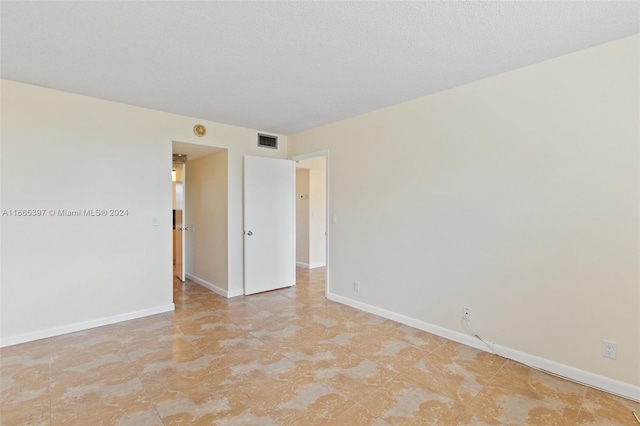 spare room featuring a textured ceiling