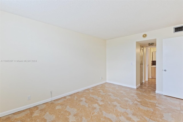 spare room with a textured ceiling