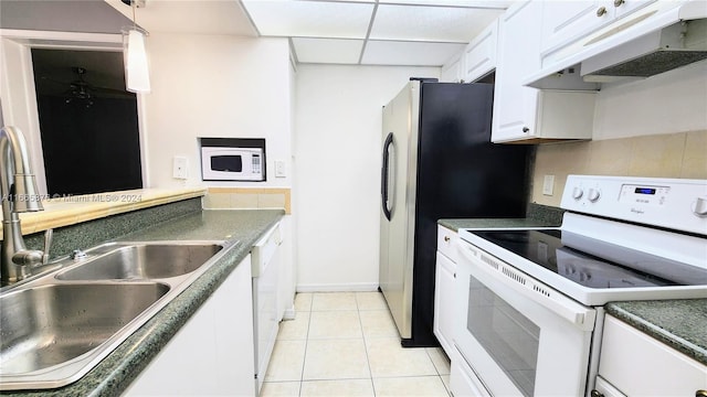 kitchen featuring sink, white cabinetry, a paneled ceiling, white appliances, and light tile patterned floors